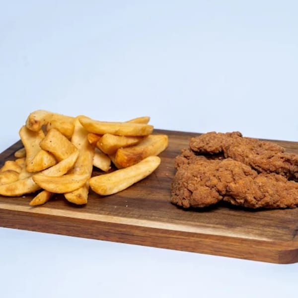 Halal Eatery's crispy chicken tenders and golden potato wedges on a wooden board.