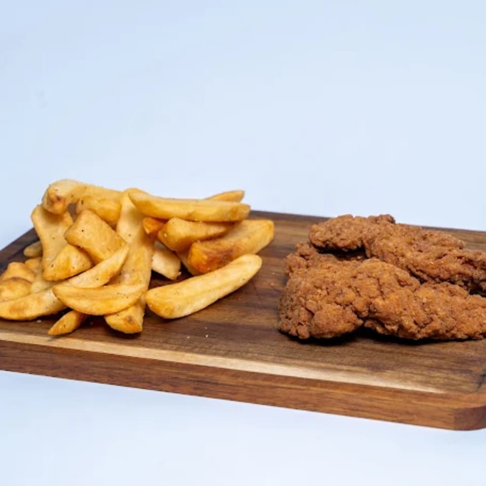 Halal Eatery's crispy chicken tenders and golden potato wedges on a wooden board.